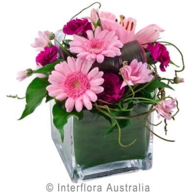 CUBE OF PINK TONES MIXED FLOWERS IN LOW GLASS CUBE AUS293